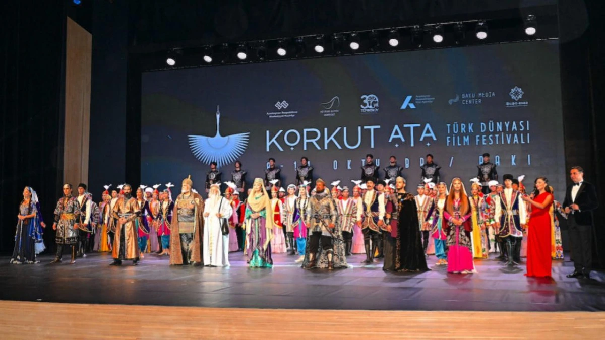 Korkut Ata Türk Dünyası Film Festivali sahnesinde geleneksel kıyafetler içindeki katılımcılar