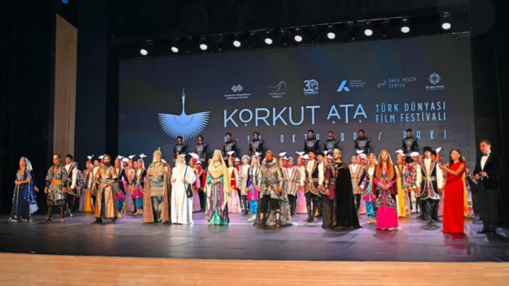 Korkut Ata Türk Dünyası Film Festivali sahnesinde geleneksel kıyafetler içindeki katılımcılar