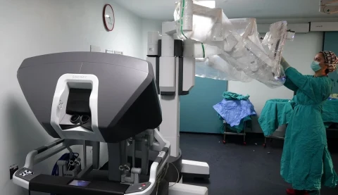 Ameliyathanede robotik cerrahi sistemi ve cerrahi ekipmanları hazırlayan sağlık çalışanı