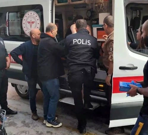 Polis eşliğindeki kişi ambulansa alınıyor