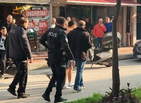 Polis ekipleri Kuşadası’nda bir kişiyi caddede götürüyor