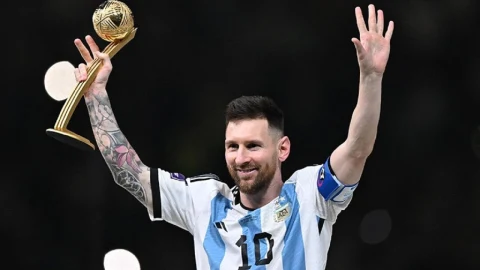 Lionel Messi, Arjantin formasıyla elinde ödül tutarak tribünlere el sallıyor