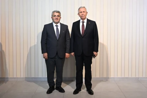 Mansur Yavaş ve bir kişi, AKSİAD’ın yeni hizmet binasının açılışında yan yana duruyor.