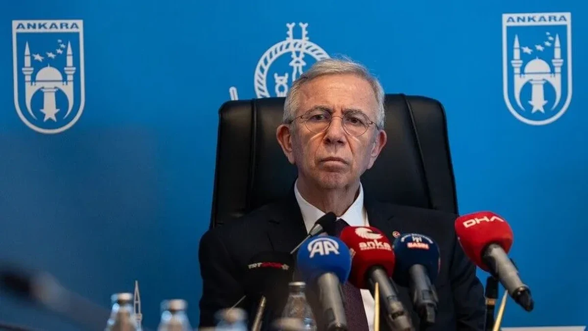 Ankara Büyükşehir Belediye Başkanı Mansur Yavaş, basın toplantısında mikrofonların önünde oturuyor.