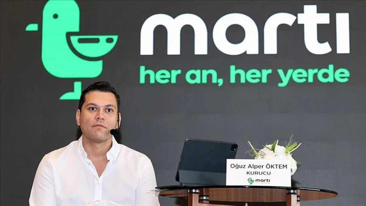 Martı TAG kurucusu Oğuz Alper Öktem, Martı logosunun önünde oturuyor.