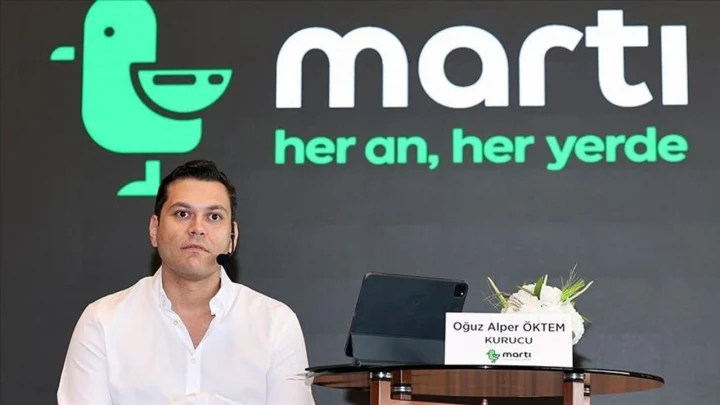 Martı TAG kurucusu Oğuz Alper Öktem, Martı logosunun önünde oturuyor.