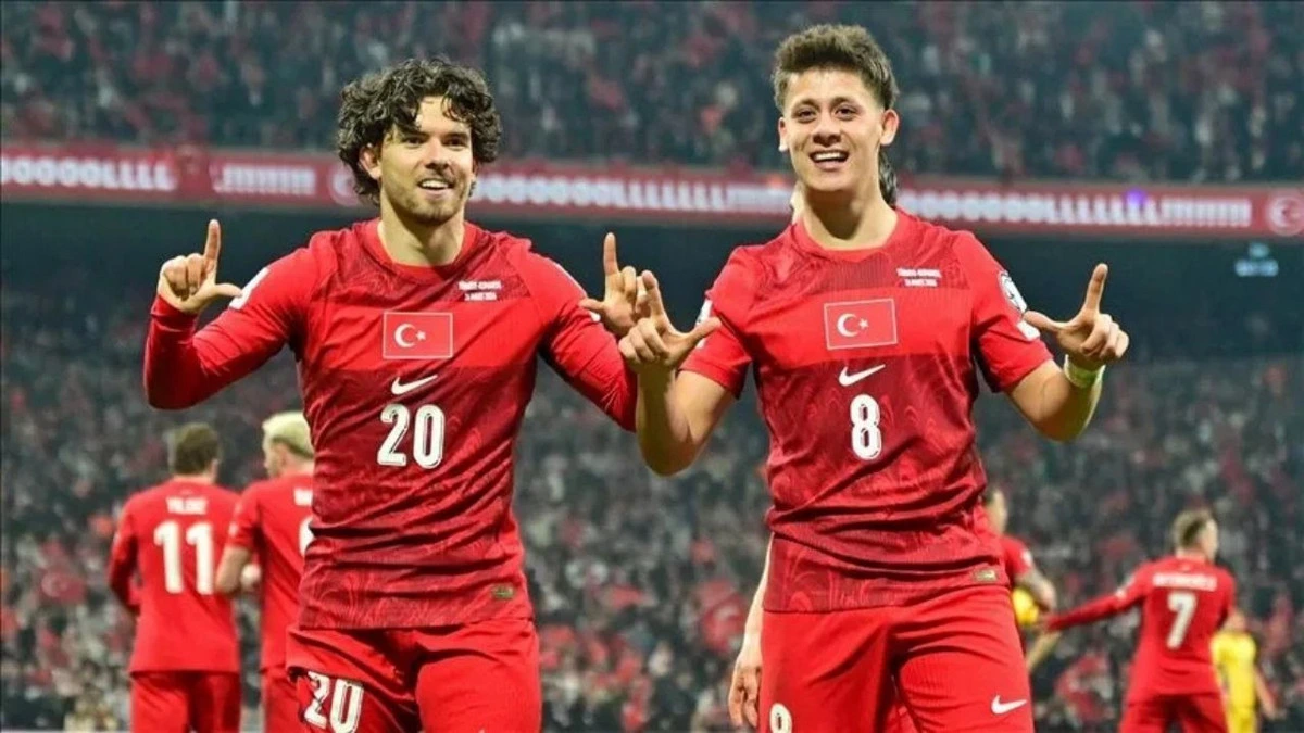 Millî takım forması giyen iki futbolcu sahada gol sevinci yaşıyor