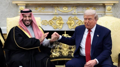 Muhammed bin Selman ve Donald Trump bir görüşmede el sıkışırken