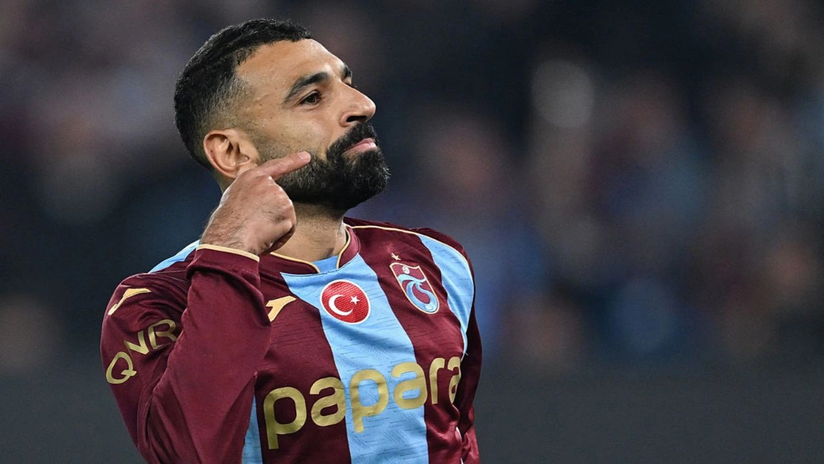 Trabzonspor forması giyen Muhammed Salah yüzünü işaret ediyor