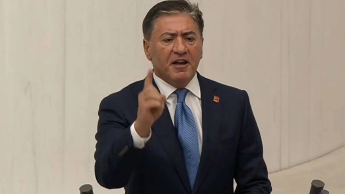 Murat Emir konuşma yaparken elini işaret eder biçimde kaldırıyor