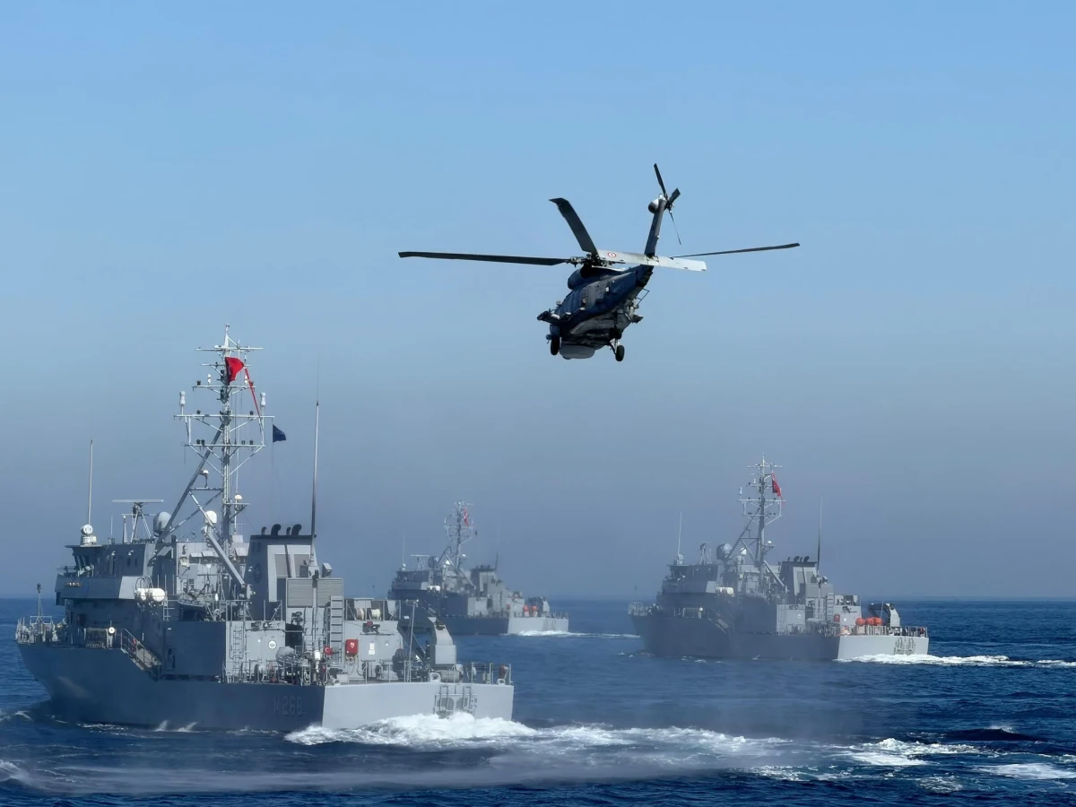 Denizde seyreden askeri gemilerin üzerinde uçan bir helikopter
