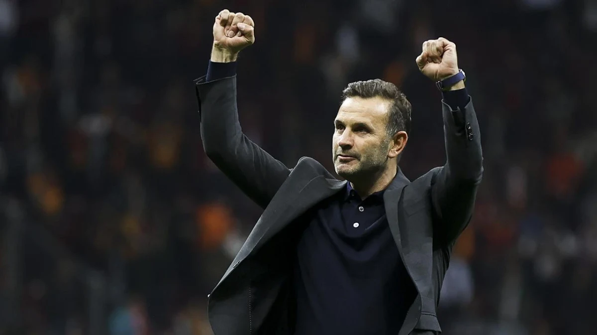 Okan Buruk, kollarını kaldırarak tribünlere doğru yumruklarını sıkıyor.