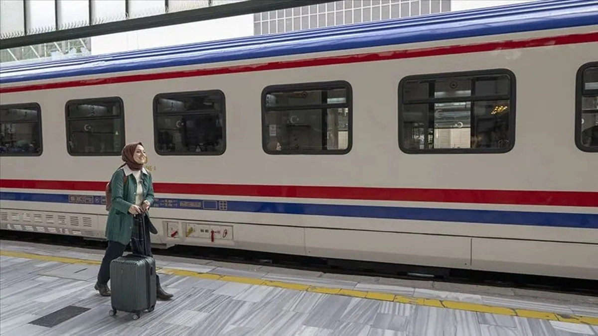 Tren istasyonunda valiziyle bekleyen yolcu ve yolcu treni