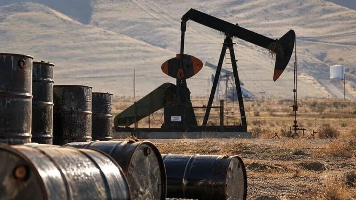 Petrol kuyusu pompası ve ön planda petrol varilleri