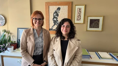Pınar Akgül Doğusoy ve bir kadın çalışma arkadaşı ofiste yan yana duruyor