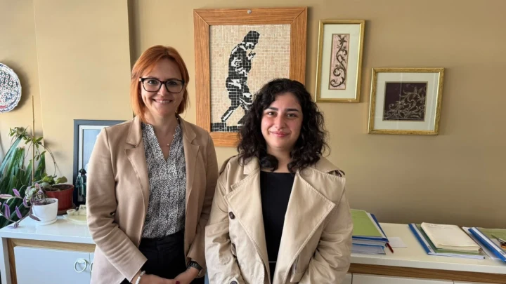 Pınar Akgül Doğusoy ve bir kadın çalışma arkadaşı ofiste yan yana duruyor