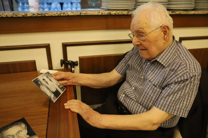 Ruşen Kökten elinde eski bir fotoğraf tutuyor.