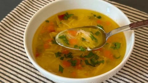 Sebzeli tavuk suyu çorbası, bir kaşıkla servis edilirken