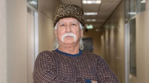 Prof. Dr. Şener Üşümezsoy koridorda ayakta duruyor