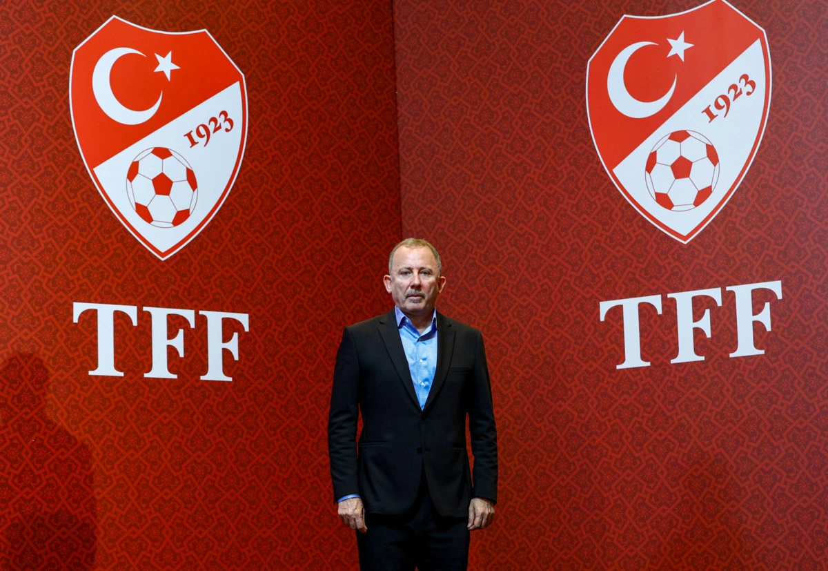 Sergen Yalçın, TFF amblemlerinin önünde ayakta duruyor.