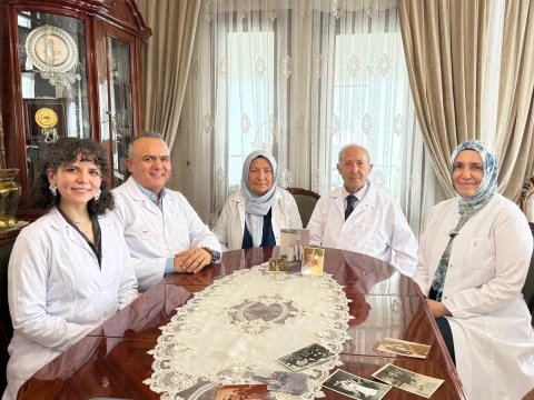 Sılay ailesinin doktor üyeleri, bir masanın çevresinde beyaz önlükleriyle birlikte oturuyor.