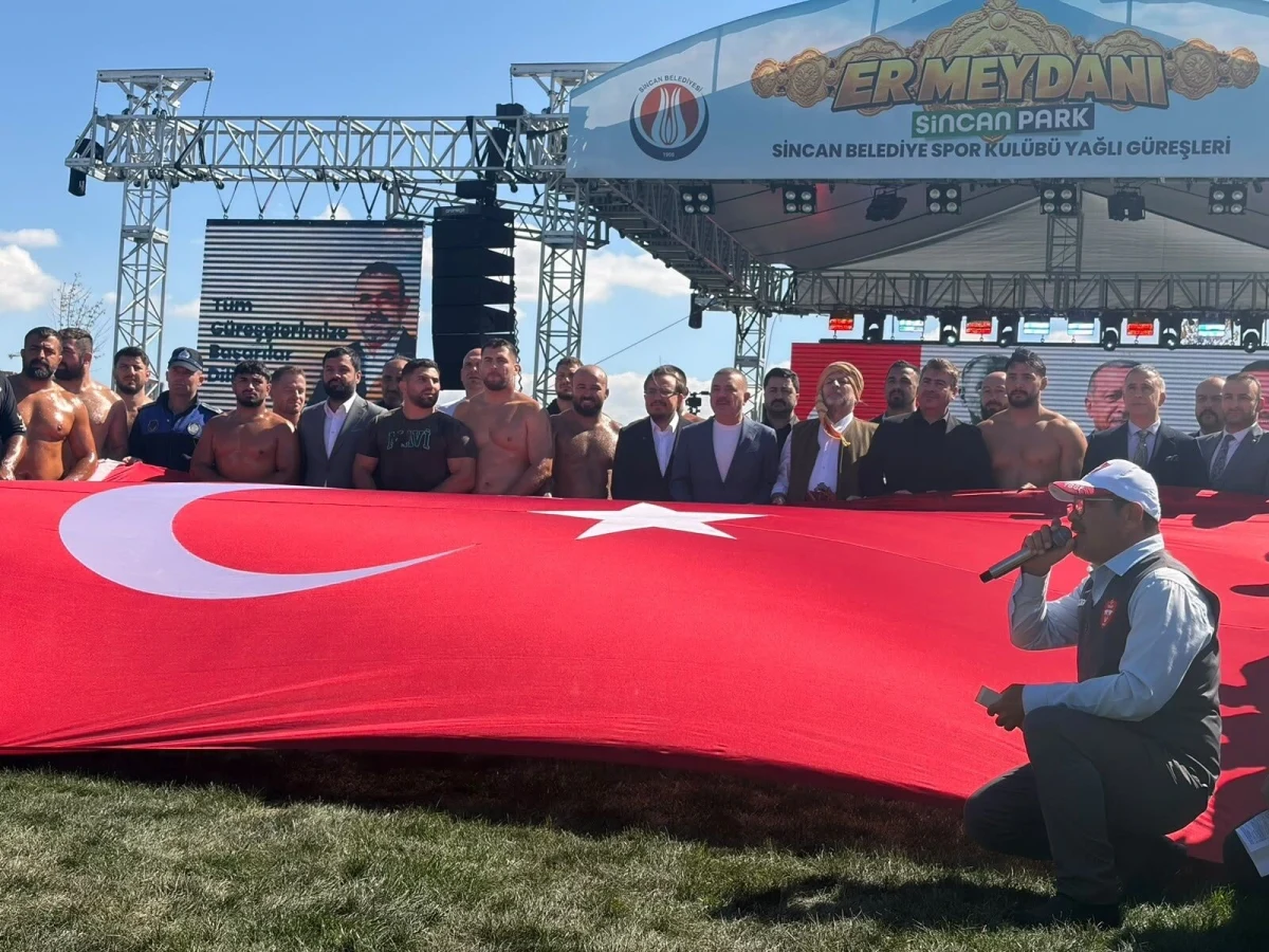 Sincan Güreş Festivali’nde büyük Türk bayrağının önünde toplu halde duran katılımcılar