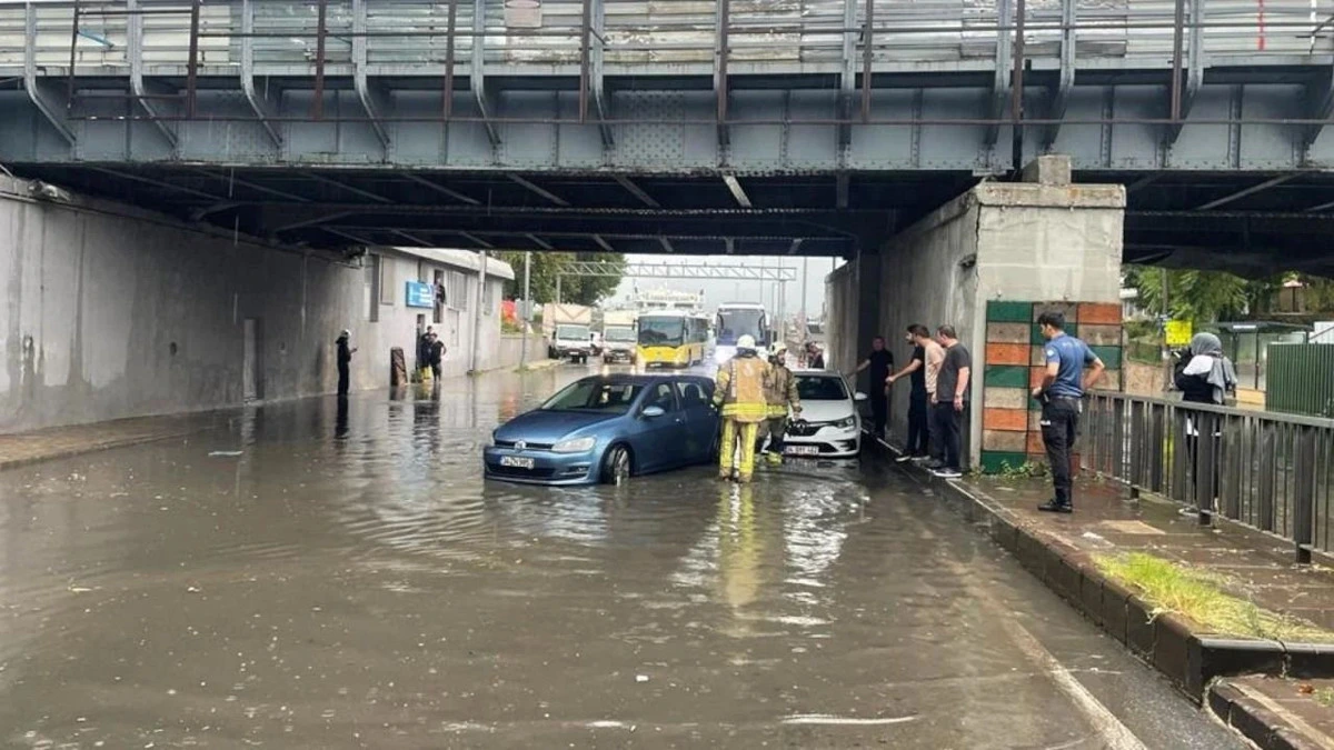 Su basmış altgeçitte araçlar ve çevrede bulunan kişiler