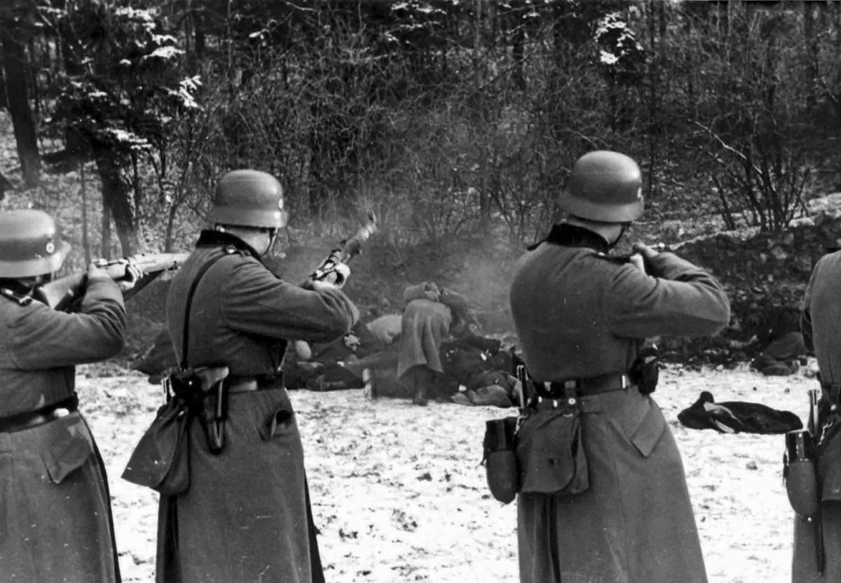 Askerlerin ormanlık alanda bir grup kişiye ateş açtığı tarihî fotoğraf