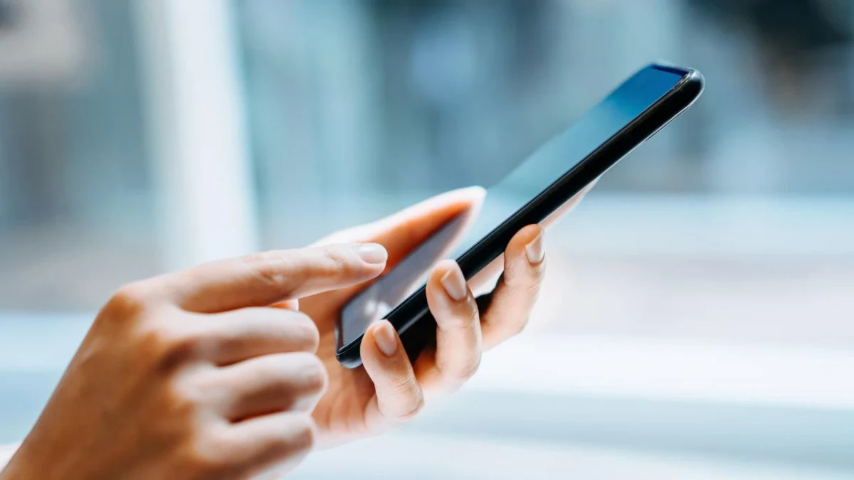 Bir kişi elindeki akıllı telefonu kullanıyor