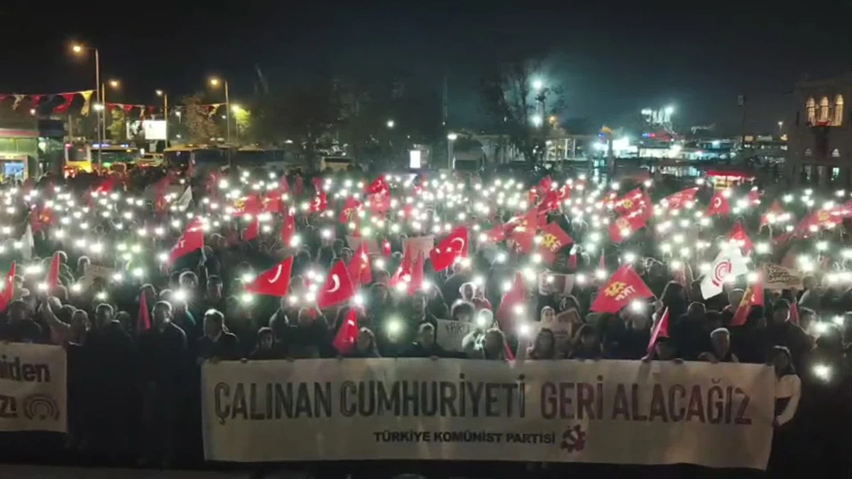 TKP yürüyüşüne katılan kalabalık, Türk bayrakları ve telefon ışıklarıyla “Çalınan Cumhuriyeti Geri Alacağız” yazılı pankart taşıyor