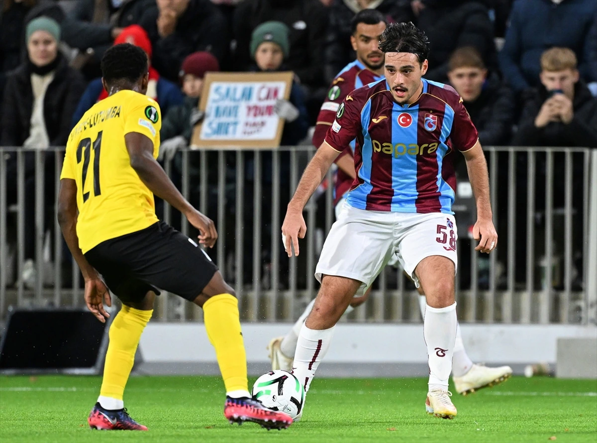 Trabzonspor futbolcusu rakip oyuncu karşısında topla ilerliyor
