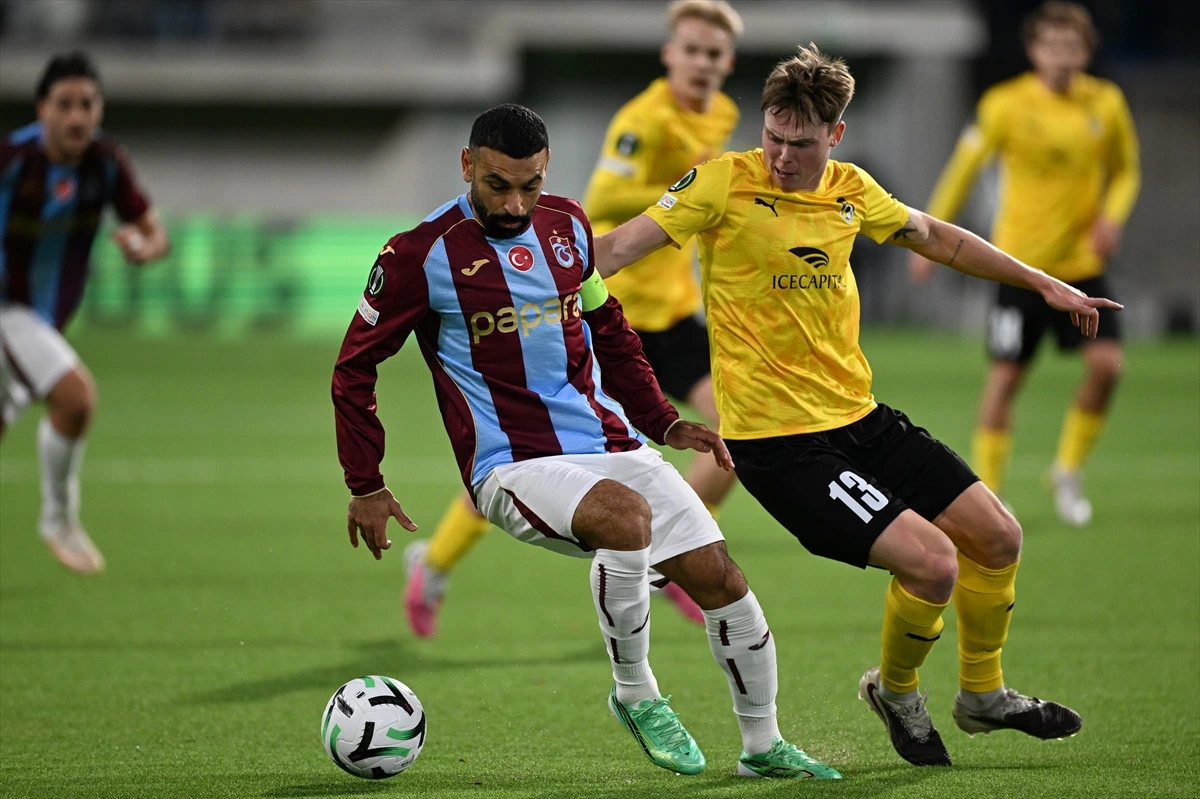 Trabzonspor forması giyen futbolcu rakibiyle top mücadelesinde