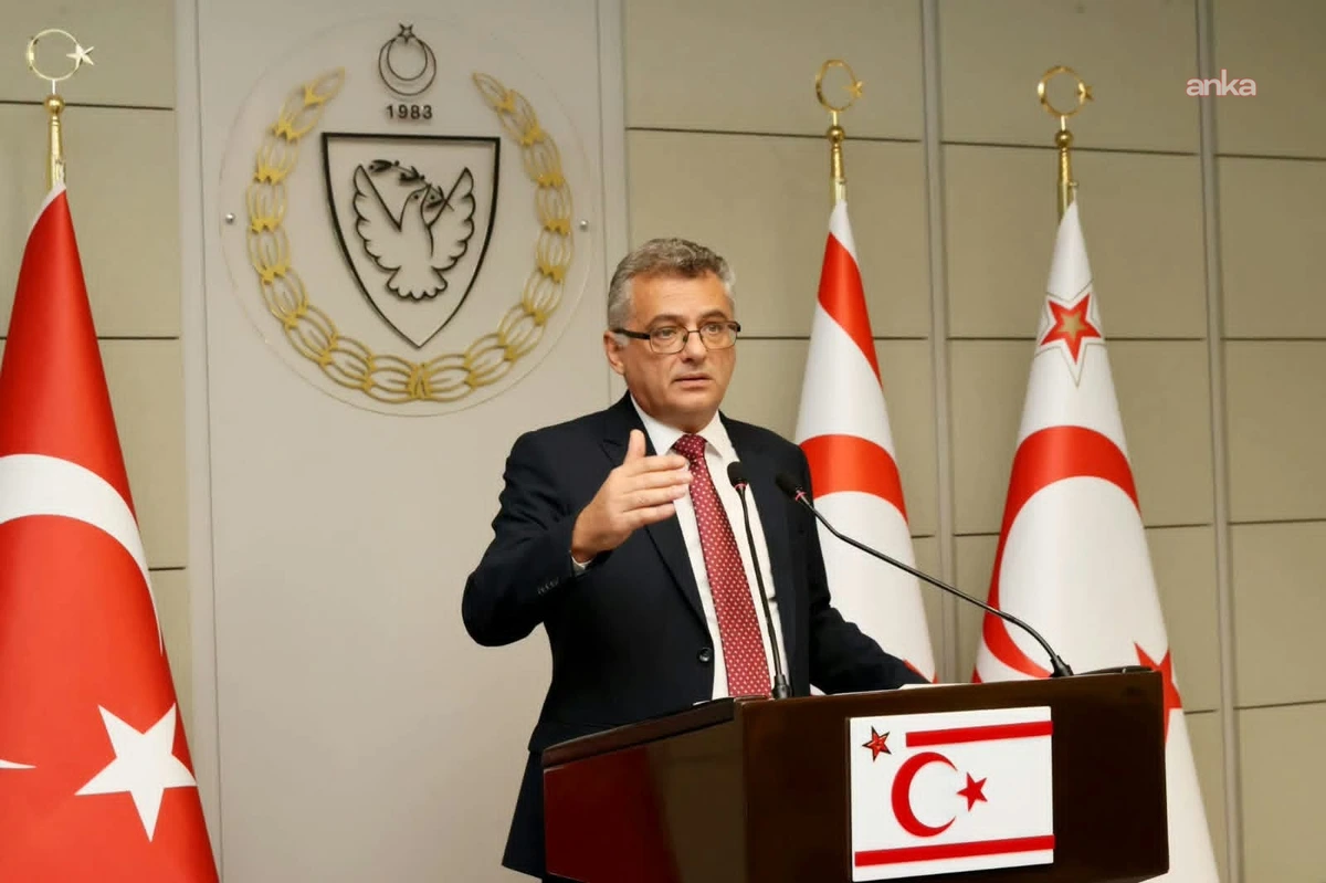 Tufan Erhürman, KKTC bayraklarının önündeki kürsüde konuşuyor.