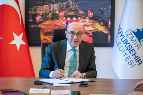 Tunç Soyer, İzmir Büyükşehir Belediyesi başkanlık makamında masada otururken