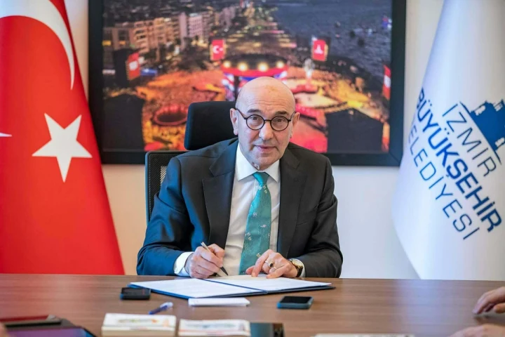 Tunç Soyer, İzmir Büyükşehir Belediyesi başkanlık makamında masada otururken