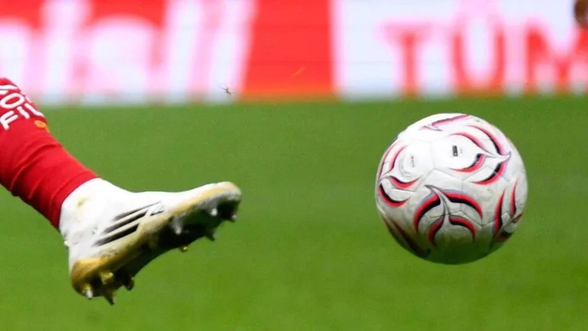 Sahada topa doğru uzanan futbolcunun ayağı