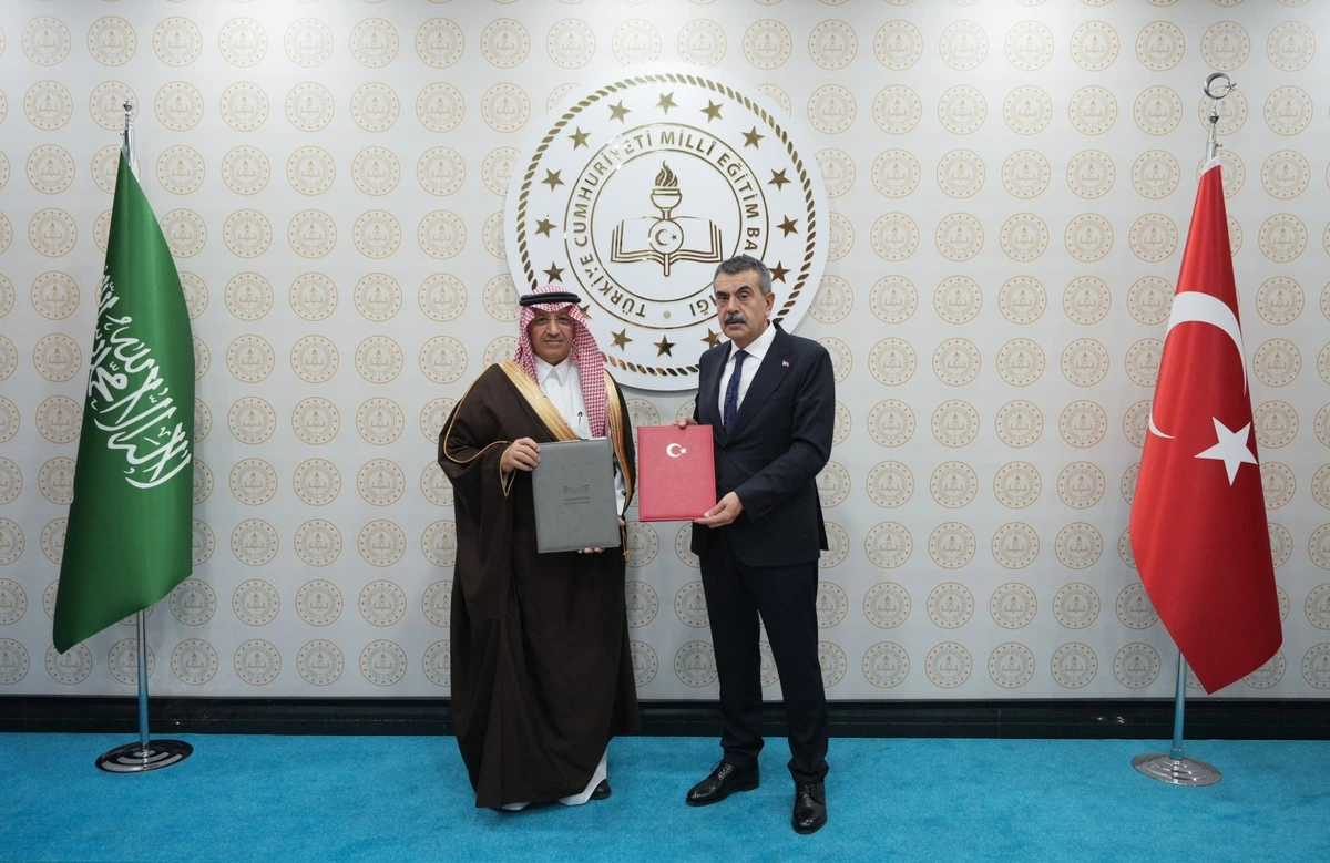 Milli Eğitim Bakanı Tekin ve Suudi Arabistan Eğitim Bakanı El-Benyan imzalanan belgelerle birlikte poz veriyor