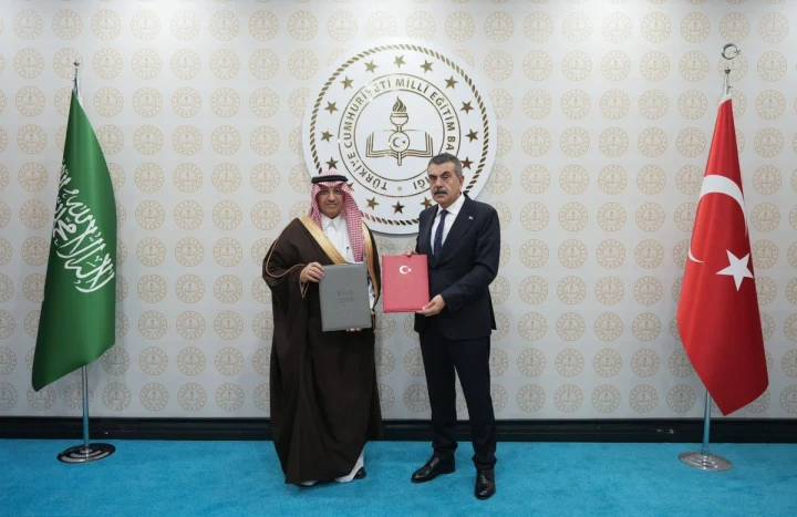 Milli Eğitim Bakanı Tekin ve Suudi Arabistan Eğitim Bakanı El-Benyan imzalanan belgelerle birlikte poz veriyor