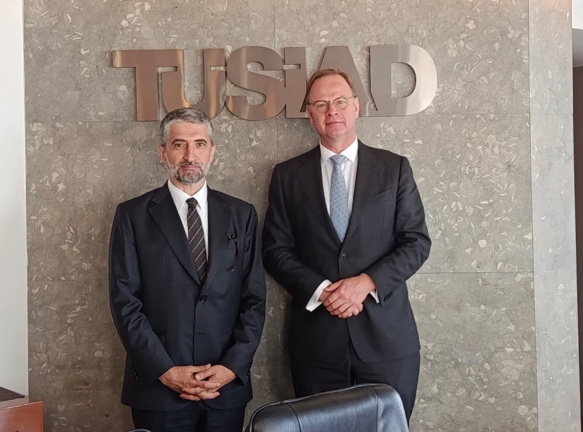 TÜSİAD Başkanı Ozan Diren ve Hollanda’nın Ankara Büyükelçisi Alle Dorhout, TÜSİAD yazısı önünde birlikte poz veriyor.