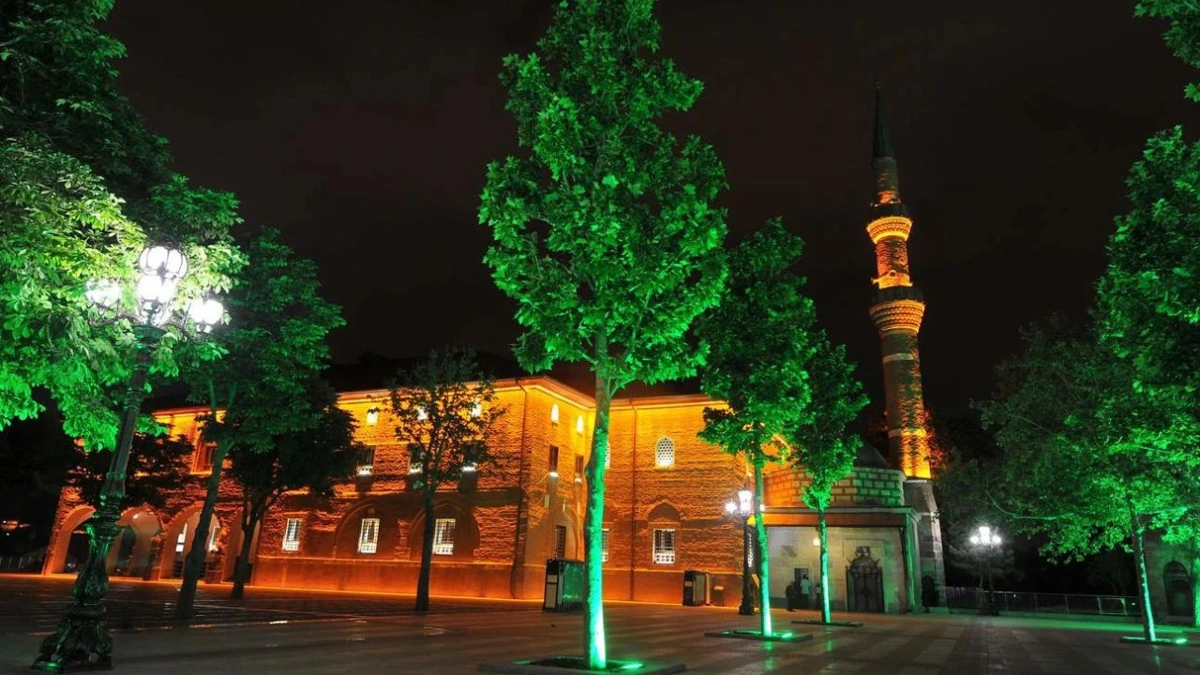 Ulus’ta gece aydınlatılmış tarihi yapı, ağaçlar ve minare