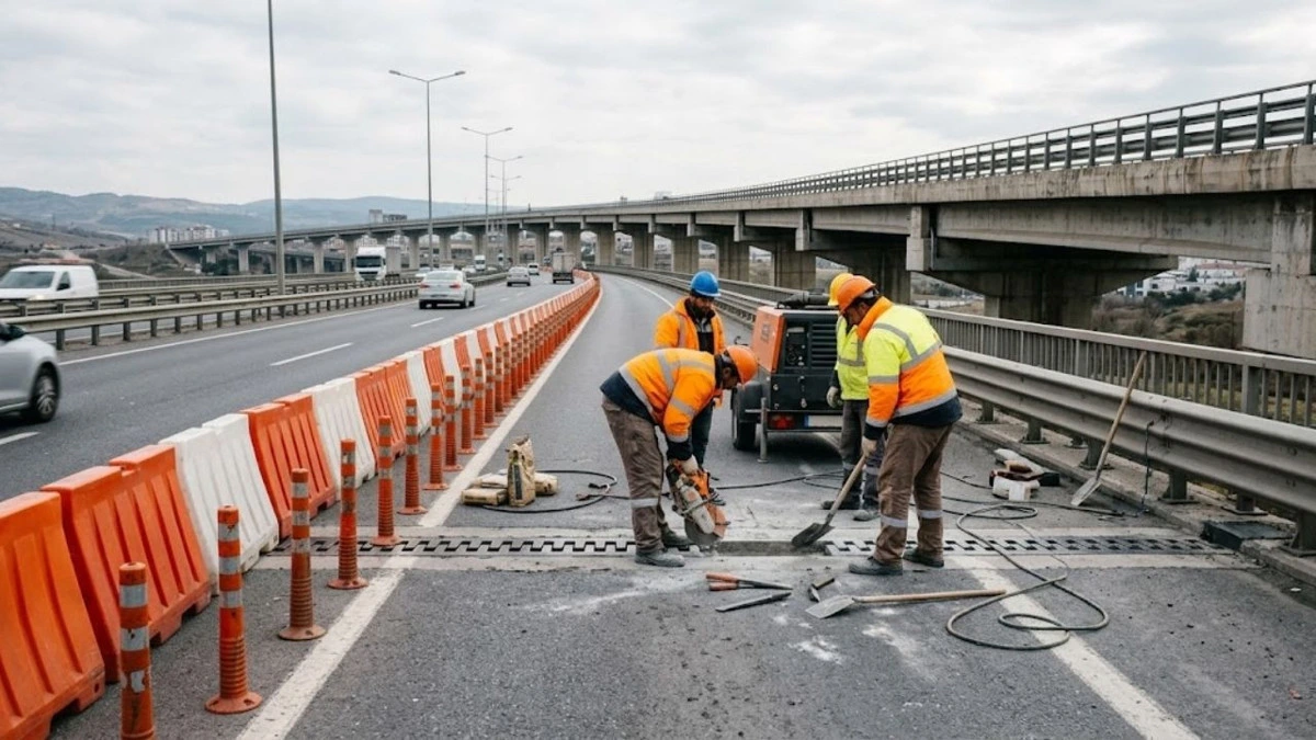 Köprü yakınında yol üzerinde çalışan işçiler ve güvenlik bariyerleri