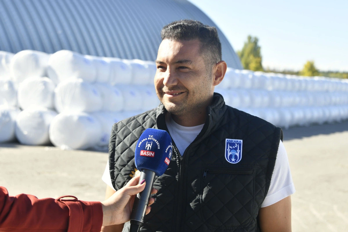 Volkan Dinçer, paketlenmiş mısır silajlarının önünde açıklama yapıyor