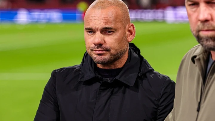 Wesley Sneijder, siyah montuyla bir futbol sahasının kenarında