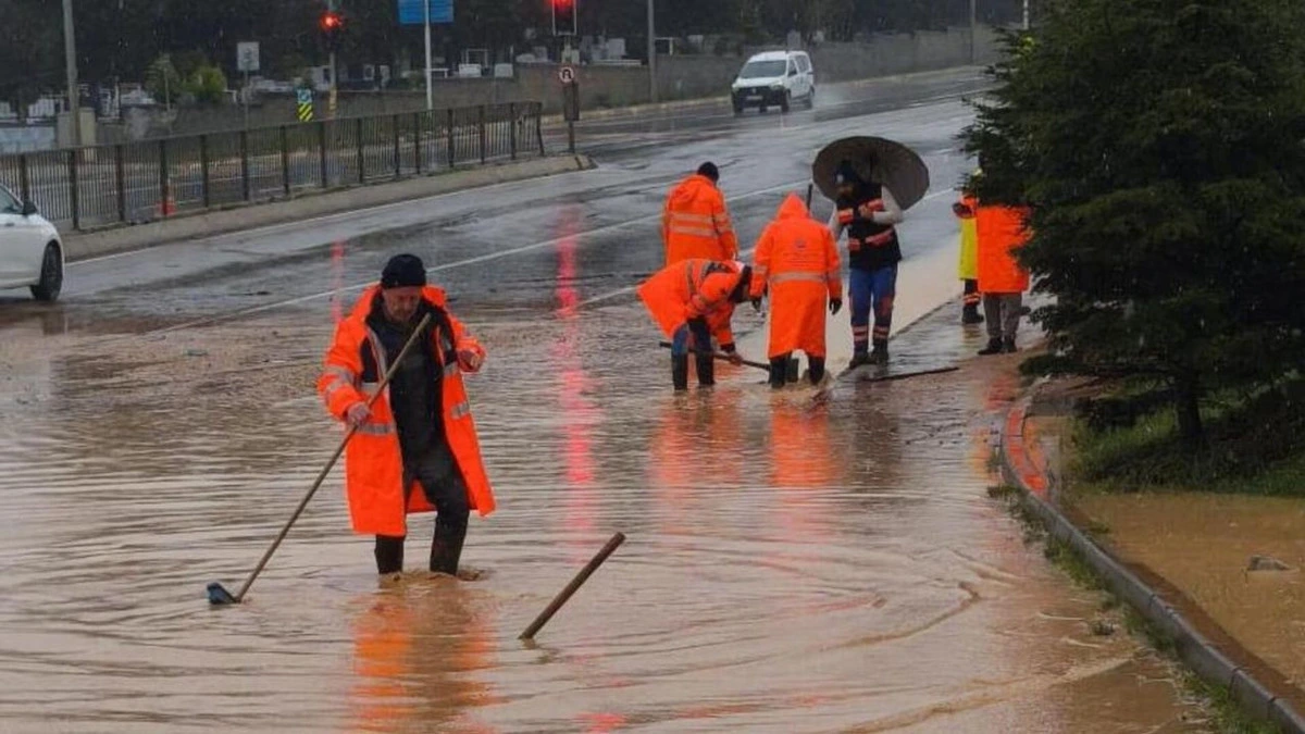 Yağış sonrası suyla kaplı yolda çalışma yapan belediye ekipleri