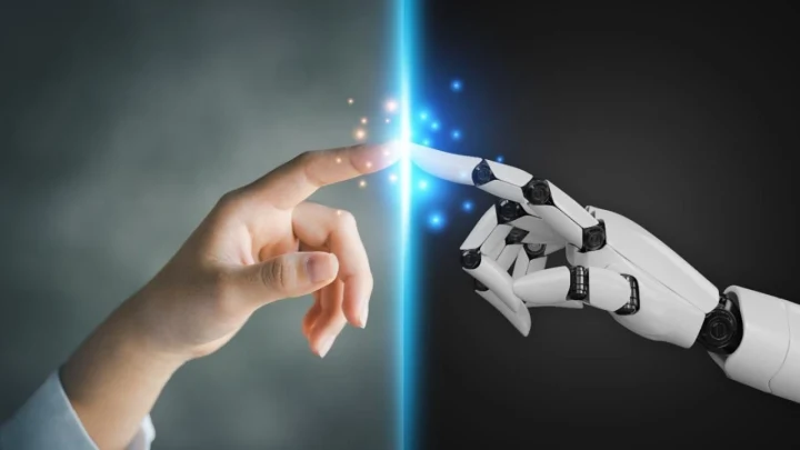 İnsan eli ile robot elinin parmak uçları ışıklı bir çizgi üzerinde birbirine dokunuyor