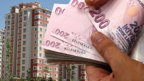 Apartmanların önünde Türk lirası banknotları tutan bir el