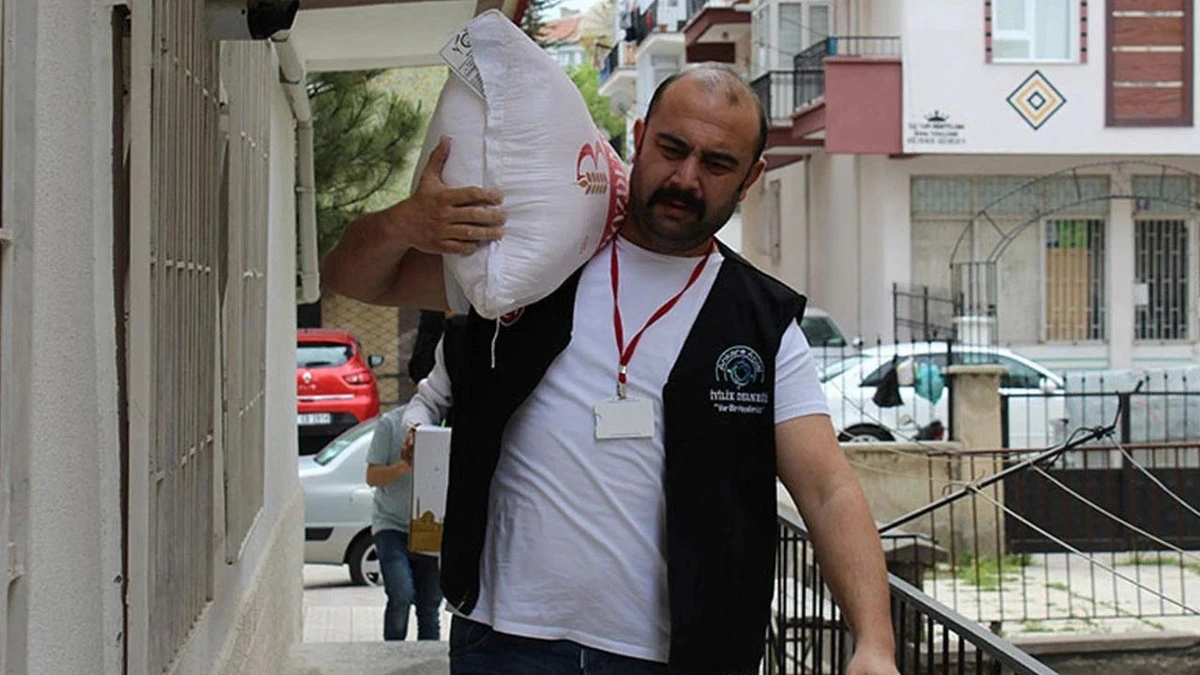 Yasin Oyanık, yardım çalışması sırasında bir çuval taşıyor.