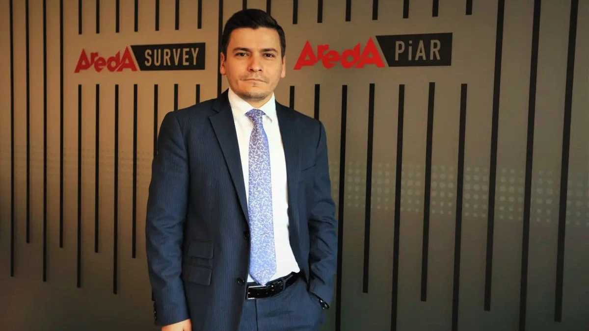 Yusuf Akın, Areda Survey ve Areda PiAR logolarının önünde duruyor