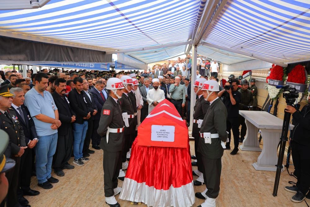 Askerlerin çevresinde taşıdığı Türk bayrağına sarılı tabut ve cenaze törenine katılanlar
