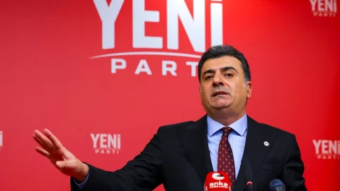Yeni Parti Sözcüsü Zeynel Emre, parti ambleminin bulunduğu kırmızı fon önünde konuşuyor